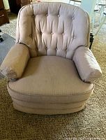 Front view showing tufted back, rolled arms, skirted base