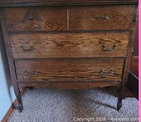 Front view of oak dresser showing all drawers and legs