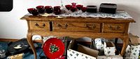Front view of oak console table showing drawers, hardware, and items on top