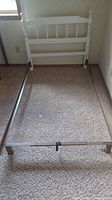 Headboard assembled with metal frame rails forming twin bed layout