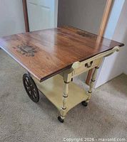 Overall view of cart with one leaf extended showing top design, wheel, drawer, shelf