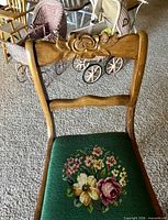 Front view highlighting carved rose on backrest and needlepoint floral seat