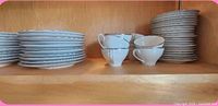 Stacks of plates and teacups on shelf