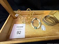 Overview of three bracelets in wooden tray