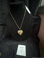 Full view of heart locket necklace on display bust