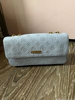 Front view of light blue Guess embossed faux leather bag