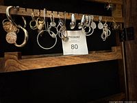 All 15 earrings hanging on rack, full view