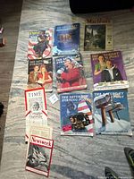 Full group of magazines laid out on rug, showing all titles