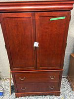 Front view of mahogany armoire with doors closed and two drawers