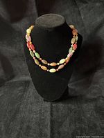 Necklace doubled on bust form showing bead colors and shape