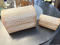 Large and small hand-carved floral wooden boxes closed, showing exterior carvings and finish