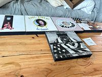 Five album art plaques on wood/MDF showing designs listed