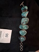 Front view of bracelet showing six turquoise stones and extender rings