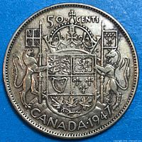 Reverse of 1947 Canada 50 cent coin showing coat of arms and date