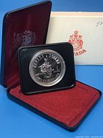Coin in open presentation case with outer sleeve visible