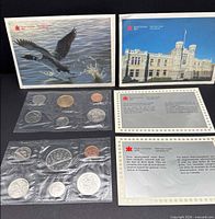 Both 1987 and 1988 coin sets with outer envelopes and COAs displayed