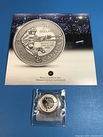 Front of illustrated card with sealed coin showing obverse hockey design
