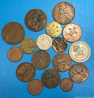 Overview of 18 assorted British coins on blue background