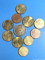 All twelve Euro coins on blue background, central 2 euro surrounded by other denominations