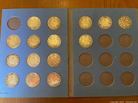 Album opened showing 15 coins on left page, right page empty