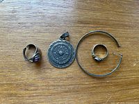 Group shot of all four sterling silver pieces on wood surface