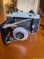 Front view showing lens, bellows and folding door