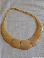 Full view of necklace laid flat showing all seven front panels and bead strand