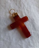 Front view of caramel Bakelite cross pendant