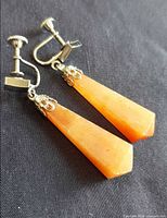 Full view of both Bakelite drop earrings on dark background showing color and shape