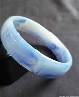 Side view of light blue marbled lucite bangle bracelet