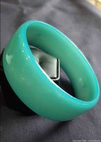 Angled view showing exterior color and width of lucite bangle