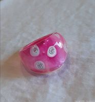 Oblique view of pink lucite ring showing glitter dot pattern