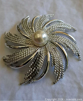 Front view of Sarah Coventry brooch showing swirl design and faux pearl centre