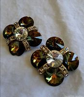 Front view showing clear central stones, brown-green crystal petals, pavé accents