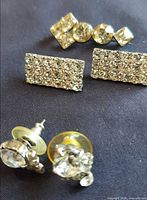 Lot overview showing bar pin, shoe clips and pair stud earrings on dark background