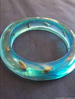 Top view of blue lucite bangle showing embedded faux beetles