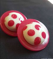 Front view showing pink disc and white domed centre with polka dots