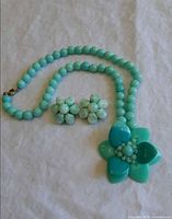 Necklace and earrings laid out showing overall design and color