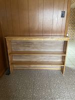 Front view of light brown wood veneer bookshelf showing overall design and dimensions
