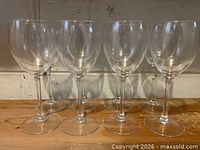 Eight clear stemmed wine glasses displayed