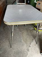 Full view of table showing top, legs, and gold trim