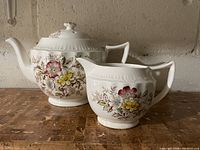 Teapot and creamer side by side showing overall form and pattern