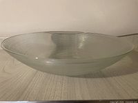 Full view of ribbed frosted glass bowl on surface