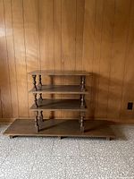 Full view of the four-tier dark brown bookcase against wall