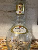 Front view showing full decanter, gold labels, starburst base