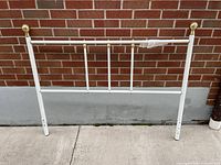 Front view of white metal headboard showing full structure