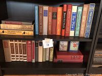 Two shelves of assorted hardcover books showing variety of classic and literary titles, colors and sizes.