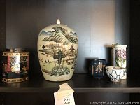 Shelf scene showing five different Asian style decorative items grouped together.