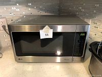 Front view of LG EasyClean microwave oven showing stainless steel finish, black tinted glass door, and digital control panel with green LED display.