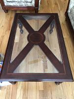 Top view of rectangular coffee table with dark wooden frame and inset glass top showing the 'X' wooden design.